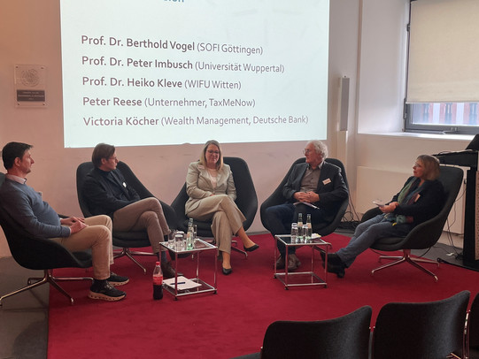 Podiumsdiskussion. 4 Personen sitzen im Kreis auf Stühlen